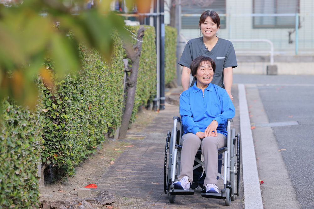 車椅子に乗った利用者さまと介護士の散歩